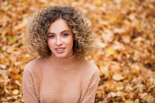 发型卷曲的头发 秋天公园里一个年轻漂亮姑娘的画像 — 图库照片