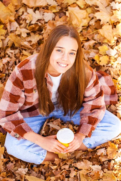 トップ表示 秋の黄色の葉の背景に美しい若い女性の肖像画 — ストック写真