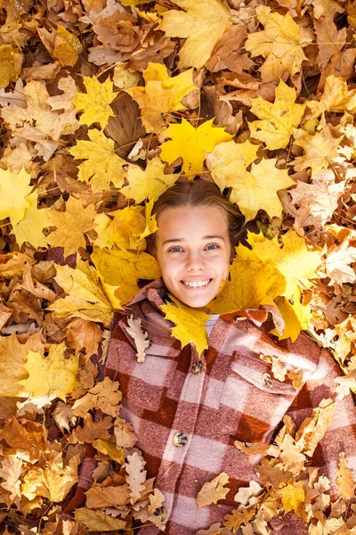 少女躺在秋天树叶上的头像 — 图库照片