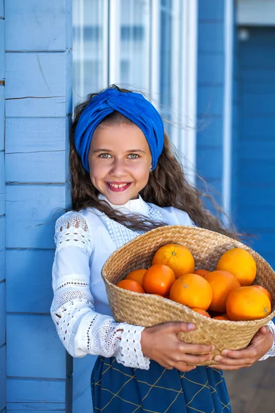 一个拿着一篮子橙子的小女孩的画像 — 图库照片