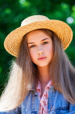 Hasır şapkalı genç bir kızın portresi.