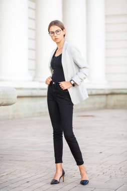 İş ceketli güzel bir kızın tam boy portresi.