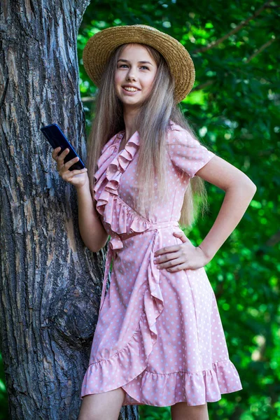 一个穿着夏装的年轻漂亮姑娘在橡木树荫下摆姿势的画像 — 图库照片