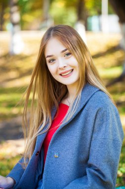 Gri paltolu güzel sarışın bir kadının portresini yakından çek.