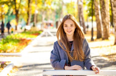 Gri paltolu güzel sarışın bir kadının portresini yakından çek.