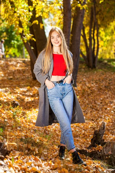 Portret Pięknej Blondynki Szarym Płaszczu Niebieskich Dżinsach Jesienny Park Świeżym — Zdjęcie stockowe