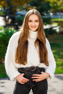 Güz parkında genç ve güzel bir esmer kadının portresi.