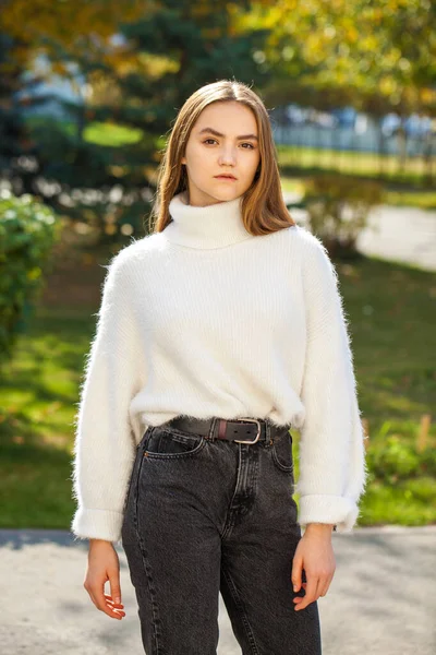 스웨터를 소녀와 공원에서 포즈를 취하고 청바지를 — 스톡 사진