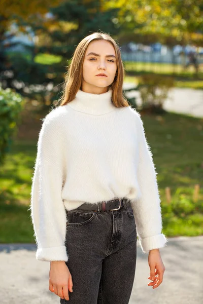 Młoda Dziewczyna Wełnianym Swetrze Czarnych Dżinsach Pozujących Jesiennym Parku — Zdjęcie stockowe