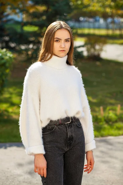 Młoda Dziewczyna Wełnianym Swetrze Czarnych Dżinsach Pozujących Jesiennym Parku — Zdjęcie stockowe