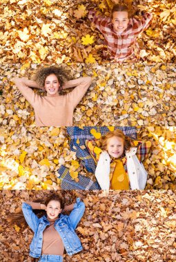 Sonbahar yeşilliklerinde yatan genç kızların kolaj manzaralı portresi.