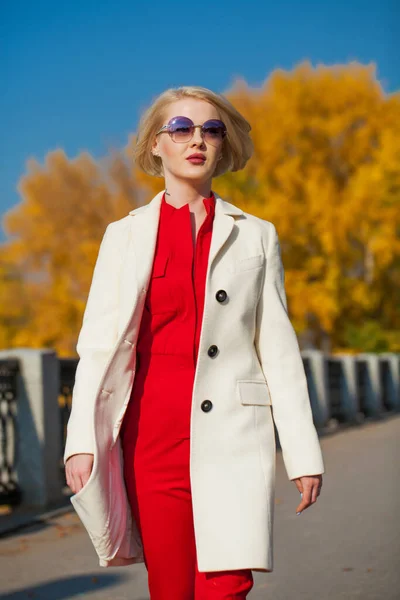 베이지 코트를 아름다운 금발의 여성은 공원을 — 스톡 사진