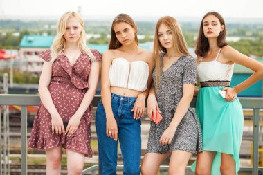 Yaz caddesinde poz veren dört güzel kadın.