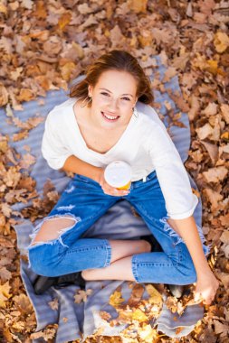 Üst manzara, arka planda güzel bir genç kadının portresi sonbahar sarı yaprakları, açık hava