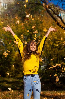 Güz parkında genç ve güzel bir esmer kadının portresi.