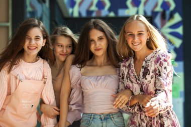 Dört neşeli kız arkadaş dükkanda yürüyor.