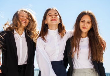 Okul üniformalı üç neşeli kız arkadaş.