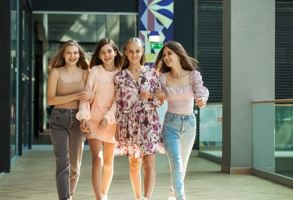 Dört neşeli kız arkadaş dükkanda yürüyor.