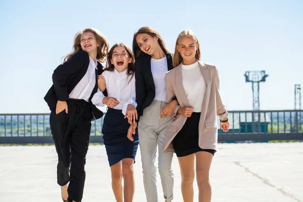 Okul üniformalı dört neşeli kız arkadaş.