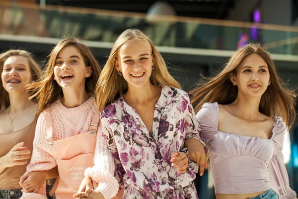 Alışveriş merkezinde dört komik kız arkadaş yürüyor.