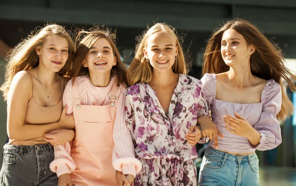 Alışveriş merkezinde dört komik kız arkadaş yürüyor.