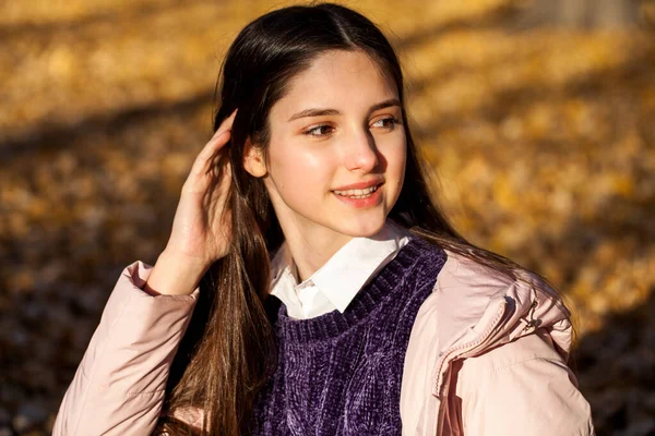 閉じる上の肖像画の若いです美しいですブルネット女性でピンクコートで秋の公園 — ストック写真