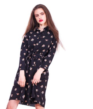 Siyah elbiseli, beyaz arka planda soyutlanmış güzel, mutlu esmer bir kadının portresi.