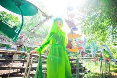 Asit yeşili yağmurluk giyen şık genç kız.