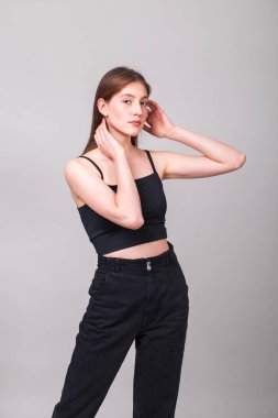 Gri arka planda izole edilmiş güzel esmer bir mankenin yakın portresi.