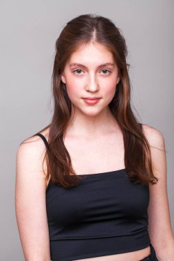 Gri arka planda izole edilmiş güzel esmer bir mankenin yakın portresi.