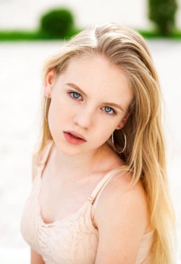 Açık havada yaz mevsiminde genç, sarışın bir kadının portresi.