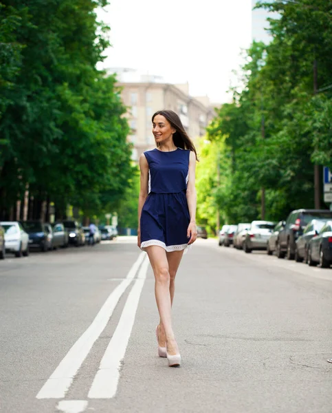 完全な成長で肖像画 道路上を歩く青い短いドレスで若い美しいブルネットの女性 夏の通り屋外 — ストック写真