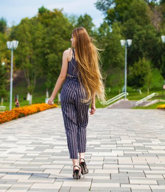 Yaz caddesinde poz veren güzel sarışın bir kadının vücut portresi.