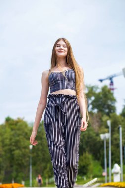 Yaz caddesinde poz veren güzel sarışın bir kadının vücut portresi.