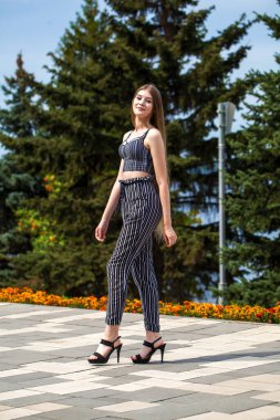 Yaz caddesinde poz veren güzel sarışın bir kadının vücut portresi.