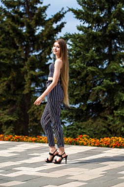 Yaz caddesinde poz veren güzel sarışın bir kadının vücut portresi.
