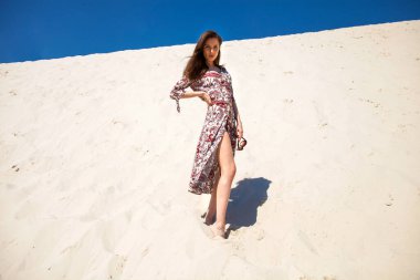 Uzun elbiseli güzel sarışın bir kızın vücut portresi.