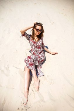 Uzun elbiseli güzel sarışın bir kızın vücut portresi.