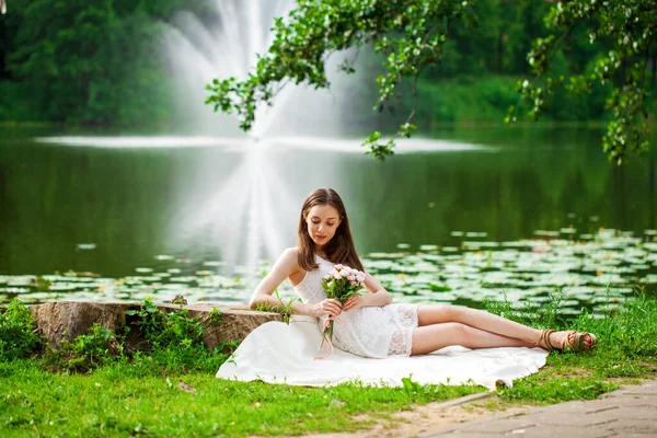 夏の公園の池の近くに眠る若い女性の全長の肖像画 — ストック写真