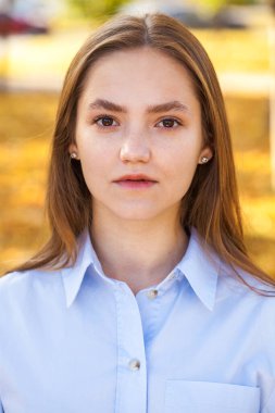 Güz parkında genç ve güzel bir esmer kadının portresi.