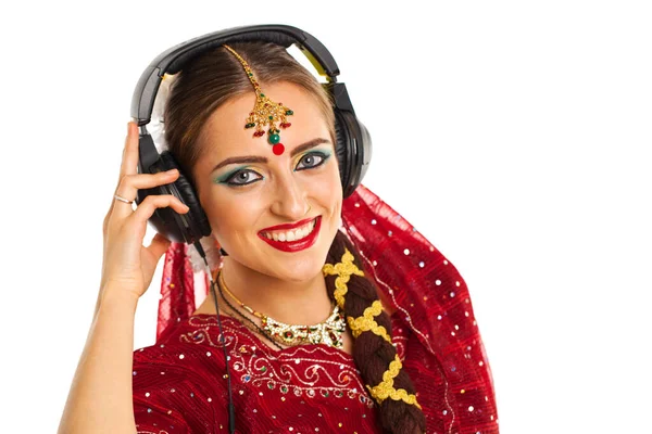 年轻美丽的印度女人在耳机里听音乐 — 图库照片