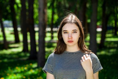 Yaz parkında genç ve güzel bir esmer kadının portresi.