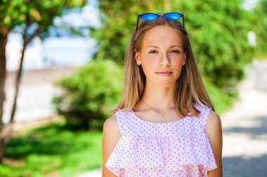 Açık havada yaz mevsiminde genç, sarışın bir kadının portresi.