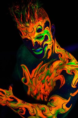 Yeraltı dünyasının ateşli adamı. Ultraviyole ışıkta parlayan vücut sanatı