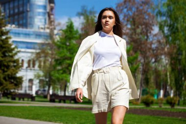 Yaz caddesinde yürüyen genç ve güzel bir iş kadını.