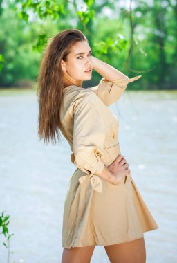 Bej elbiseli güzel esmer kadının portresi.