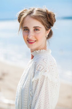 Beyaz elbiseli güzel esmer bir kadının yakın portresi.