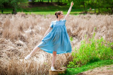 Bir yaz parkında, turkuaz bir elbise içindeki güzel bir kadının portresi.