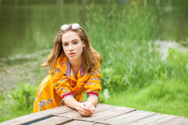 Gölün kenarında poz veren sarışın güzel bir kızın portresi.