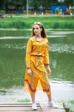 Göl kenarında poz veren sarışın güzel bir kızın vücut portresi.